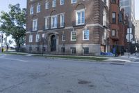 an apartment building at the corner of a street with a blue fire hydrant in front