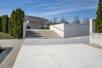 concrete steps and stairs leading to a building with trees in the background on a sunny day