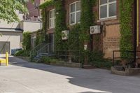 a paved sidewalk in an old, run down town neighborhood with a sidewalk sign on it