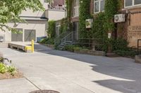 a paved sidewalk in an old, run down town neighborhood with a sidewalk sign on it