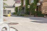 a paved sidewalk in an old, run down town neighborhood with a sidewalk sign on it