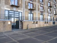 an empty parking lot in front of a tall apartment building with a balcony, balconies and balconies