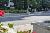 a car driving down an empty street lined with tall buildings and trees in the background