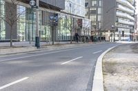 an empty road in the city near a building with a clock on it's side