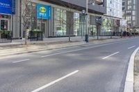 an empty road in the city near a building with a clock on it's side