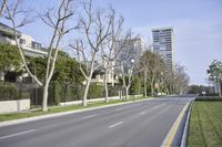 a lone empty street near the buildings and trees in a residential area in the city