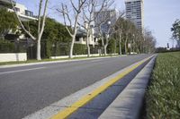 a lone empty street near the buildings and trees in a residential area in the city