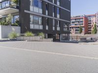 a man riding his skateboard in front of a gray building with stairs leading to the entrance