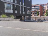 a man riding his skateboard in front of a gray building with stairs leading to the entrance