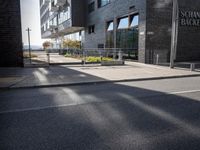 an image of the street that is next to the building on which there are many bikes