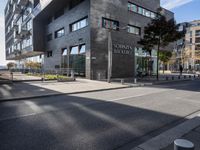 an image of the street that is next to the building on which there are many bikes