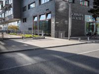 an image of the street that is next to the building on which there are many bikes