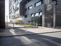 an image of the street that is next to the building on which there are many bikes