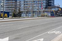 an empty street with white arrows painted on the ground next to a shopping mall in a city