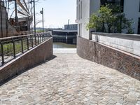 the sidewalk is set into a concrete wall and bricks along with iron fences on both sides