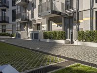 modern apartment buildings with balconies and an empty cobblestone road in the sun