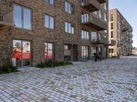 some buildings that are next to each other on street bricks in front of a couple of windows