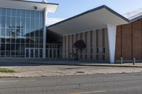 a brick and glass building sits outside of the middle school, with grass on the ground