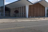 a brick and glass building sits outside of the middle school, with grass on the ground