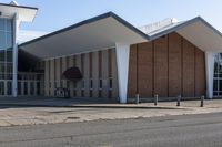 a brick and glass building sits outside of the middle school, with grass on the ground