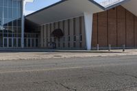 a brick and glass building sits outside of the middle school, with grass on the ground