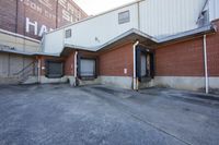 a garage is next to a building and two steps up the side of it that are closed down