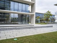 a person sitting on a bench in a building with glass windows and a lawn area