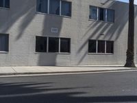 a view of a building from the street with trees in front of it and a fire hydrant on the sidewalk