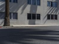 a view of a building from the street with trees in front of it and a fire hydrant on the sidewalk