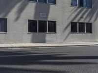 a view of a building from the street with trees in front of it and a fire hydrant on the sidewalk