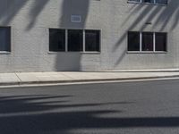 a view of a building from the street with trees in front of it and a fire hydrant on the sidewalk