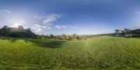 a 360 view of an open area with trees and grass in it and the sky above