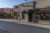 a storefront with black awnings on the sidewalk with a road in front of it