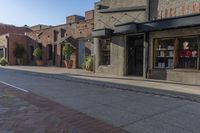 a storefront with black awnings on the sidewalk with a road in front of it