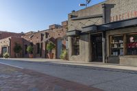 a storefront with black awnings on the sidewalk with a road in front of it