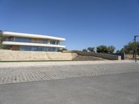 the concrete walkway is paved with a brick path near the house to the roof and the stairs are made out of bricks