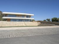 the concrete walkway is paved with a brick path near the house to the roof and the stairs are made out of bricks