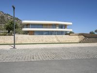 the concrete walkway is paved with a brick path near the house to the roof and the stairs are made out of bricks