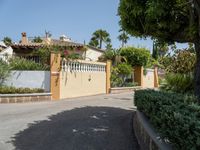 this is a driveway with some shrubs and a building in the distance, and there is an umbrella at the top