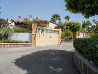 this is a driveway with some shrubs and a building in the distance, and there is an umbrella at the top