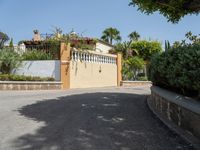 this is a driveway with some shrubs and a building in the distance, and there is an umbrella at the top