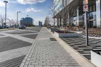 a empty sidewalk beside the curb where there are a lot of parked cars and a building