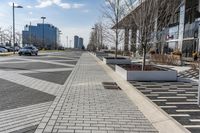 a empty sidewalk beside the curb where there are a lot of parked cars and a building