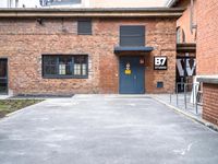 parking area at the front of a brown brick building with a number 30 painted on the door