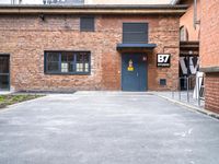 parking area at the front of a brown brick building with a number 30 painted on the door