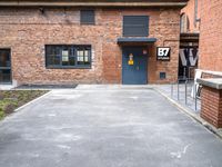 parking area at the front of a brown brick building with a number 30 painted on the door