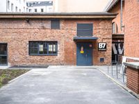 parking area at the front of a brown brick building with a number 30 painted on the door