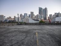 a concrete parking lot with buildings in the background on the top of it and in front of the other