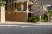 a man is riding a skateboard down the sidewalk in front of an apartment building