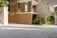 a man is riding a skateboard down the sidewalk in front of an apartment building